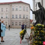 pomnik Jana Pawła II w Wadowicach, Iwona Gibas i ks. Łukasz Piórkowski składają kwiaty pod pomnikiem